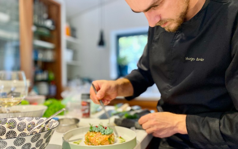 Hugo Bouvier, chef cuisinier chez Saveurs Privées en pleine préparation d'un tartare de saumon à la spiruline